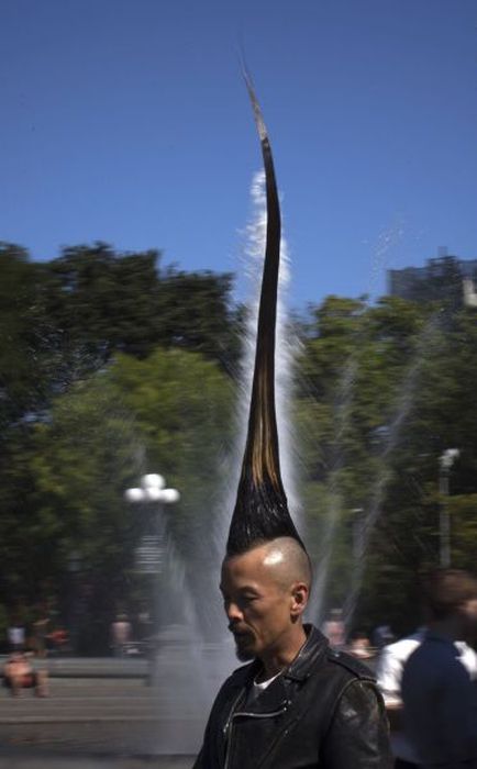 Japanese fashion designer Kazuhiro Watanabe, who holds the world record for the "Tallest Mohawk," walks past a water fountain in Washington Square Park